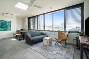 a living room with a couch and chairs and windows at EIGHT TWO NINE TWO IV: BONDI BEACH in Sydney