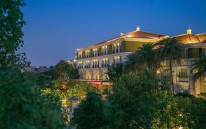 a large building with palm trees in front of it at Riyuegu Hotsprings Resort in Xiamen