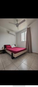 - une chambre avec un lit rouge et une fenêtre dans l'établissement Rayon de Soleil T2 Bas de villa, à Sainte-Anne