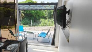 Elle offre une vue sur une terrasse dotée de chaises et d'une table. dans l'établissement Rayon de Soleil T2 Bas de villa, à Sainte-Anne