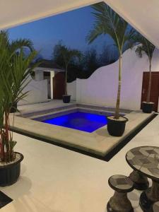 a swimming pool with palm trees in a room at Uluwatu Stay's Standard Room #1 in Uluwatu
