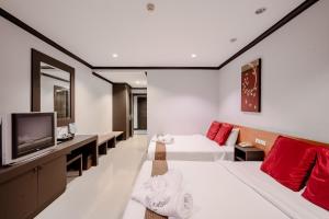 a hotel room with two beds and a flat screen tv at Napalai Resort & Spa in Hua Hin