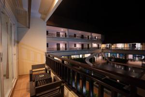 a building with a balcony with benches and a pool at Napalai Resort & Spa in Hua Hin
