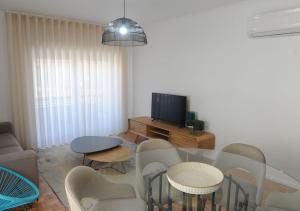 een woonkamer met een tafel en stoelen en een televisie bij APARTAMENTO CENTRAL in Mondim de Basto
