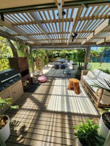 an outdoor patio with a wooden pergola at The Sanctuary Papamoa Beach in Papamoa