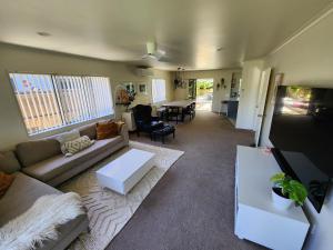 a living room with a couch and a table at The Sanctuary Papamoa Beach in Papamoa