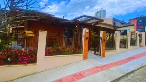 a building with a gate and flowers in front of it at Pousada Quatro Estações in Gravatal