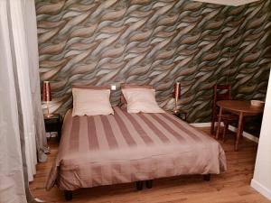 a bedroom with a bed with a stone wall at Domaine de la Moselle in Saint-Maurice-sur-Moselle