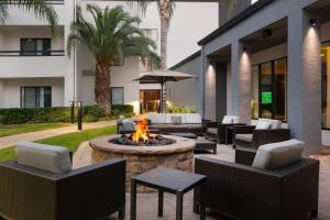 a patio with a fire pit and chairs and a building at Courtyard by Marriott Fresno in Fresno