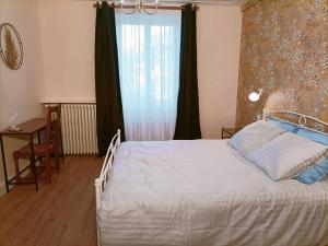 1 dormitorio con 1 cama blanca y ventana en Domaine de la Moselle, en Saint-Maurice-sur-Moselle