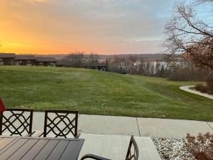 a patio with a table and chairs and a field of grass at Newly Updated Modern, Spacious, and Cozy Condo- Right on the Lake! in Lake Geneva