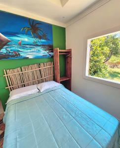 um quarto com uma cama com um quadro na parede em Suíte em Sítio a 5 minutos da praia em Porto Seguro