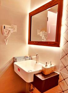 y baño con lavabo blanco y espejo. en HANZ Bao Long Hotel, en Ho Chi Minh