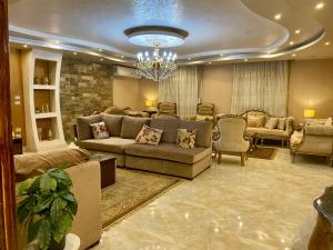 a living room with a couch and chairs and a chandelier at Cozy 3BR Apartment in Maadi in Cairo