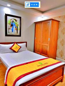 1 dormitorio con 1 cama grande y armario de madera en HANZ Bao Long Hotel, en Ho Chi Minh