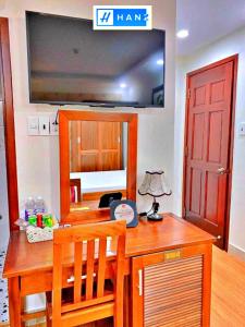 Habitación con mesa de madera y puerta roja. en HANZ Bao Long Hotel, en Ho Chi Minh