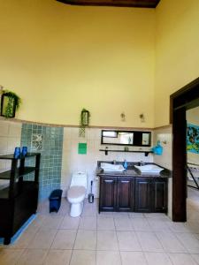 ein Bad mit einem WC und einem Waschbecken in der Unterkunft Villa Martina Palmgarden in Sámara