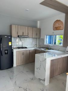 uma cozinha com armários de madeira e um frigorífico preto em Compostela Cabañas Gigante em Gigante