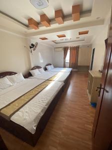 a bedroom with two beds in a room at Khách sạn Trung Hiếu in áº¤p VÄ©nh ÃÃ´ng