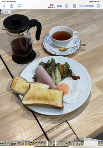 einen Teller mit Frühstücksspeise und eine Tasse Tee in der Unterkunft Gallery Compass in Osaka