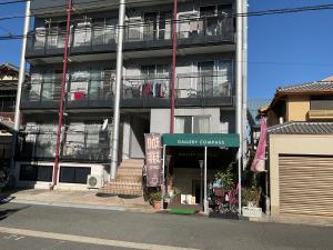 an apartment building with a sign in front of it at Gallery Compass in Osaka