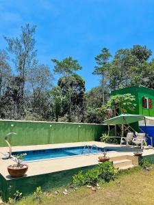 a house with a swimming pool in a yard at Suíte em Sítio a 5 minutos da praia in Porto Seguro