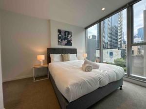a bedroom with a large bed and a large window at Nest Apartments on Rose Lane in Melbourne