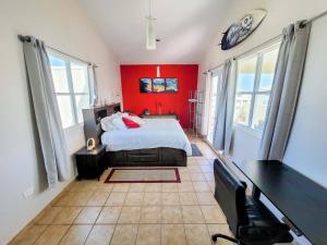 ein rotes Schlafzimmer mit einem Bett und einem Schreibtisch in der Unterkunft Paradise Beach Home @Jobos beach in Isabela