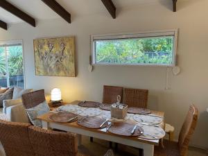 阿希帕拉的住宿－AHIPARA GOLDENSANDs，一间带桌椅和窗户的用餐室