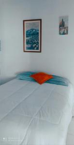 a white bed in a bedroom with a picture on the wall at Cantinho da Rota in São Roque