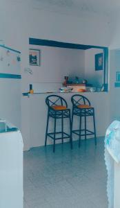 two bar stools in a kitchen with a counter at Cantinho da Rota in São Roque