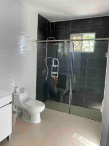 a bathroom with a toilet and a glass shower at Espaciosa casa en Matancitas a 3 min de la Playa in Matancita