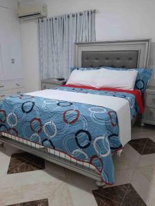 a bedroom with a bed with a blue and red blanket at Espaciosa casa en Matancitas a 3 min de la Playa in Matancita