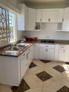 a kitchen with white cabinets and a sink at Espaciosa casa en Matancitas a 3 min de la Playa in Matancita