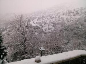 una luz de la calle cubierta de nieve en una montaña en Casa Lanoi en Sirako