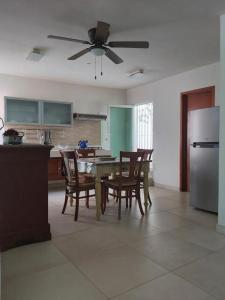 cocina con mesa, sillas y nevera en Amplio apartamento en zona residencial bien ubicada cerca del mar en Mazatlán