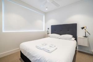 Un dormitorio con una cama blanca con toallas. en EIGHT TWO NINE TWO V: BONDI BEACH en Sídney