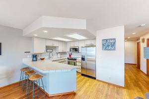 uma cozinha com armários brancos e electrodomésticos de aço inoxidável em Lake Chelan Shores: The Overlook #19-9 em Chelan