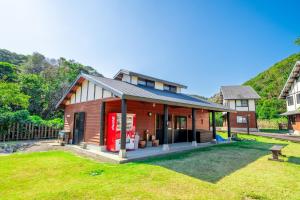 a house with a coke machine in a yard at Tsushima Miuda Pension in Tsushima