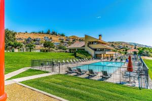 a swimming pool with chairs and a house at Lake Chelan Shores: The Overlook #19-9 in Chelan