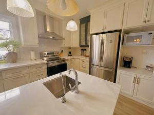 eine Küche mit weißen Schränken und einem Kühlschrank aus Edelstahl in der Unterkunft ROOM D IN THE WHITE HOUSE in Niagara Falls