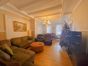 a living room with a couch and a christmas tree at ROOM D IN THE WHITE HOUSE in Niagara Falls