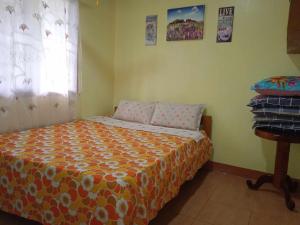 una camera da letto con un letto con un copriletto arancione e una finestra di franky jay house a Esperanza