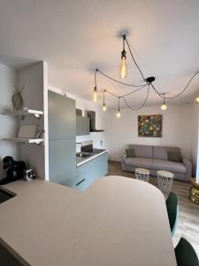 cocina y sala de estar con mesa y sofá en Superbe studio climatisé parking gratuit sur place, en Bonifacio
