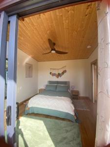 a bedroom with a bed with a ceiling fan at Evergreen Cabin in Primrose Sands