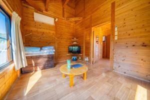 uma cabana de madeira com uma mesa e uma televisão em Tsushima Miuda Pension em Tsushima