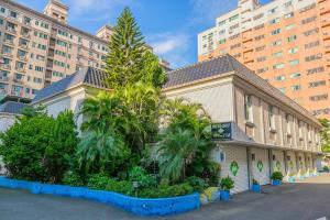 a building with palm trees in front of a building at King Motel王者 in Taoyuan