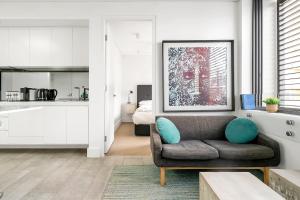 a living room with a couch and a kitchen at EIGHT TWO NINE TWO VI: BONDI BEACH in Sydney