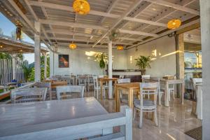 a restaurant with tables and chairs in a room at Kelingking Sunset Point Hotel & Spa in Klungkung