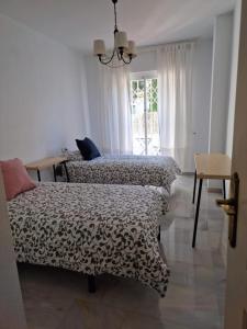 1 dormitorio con 2 camas y ventana en Ola Blanca Carihuela Apartamento, en Torremolinos